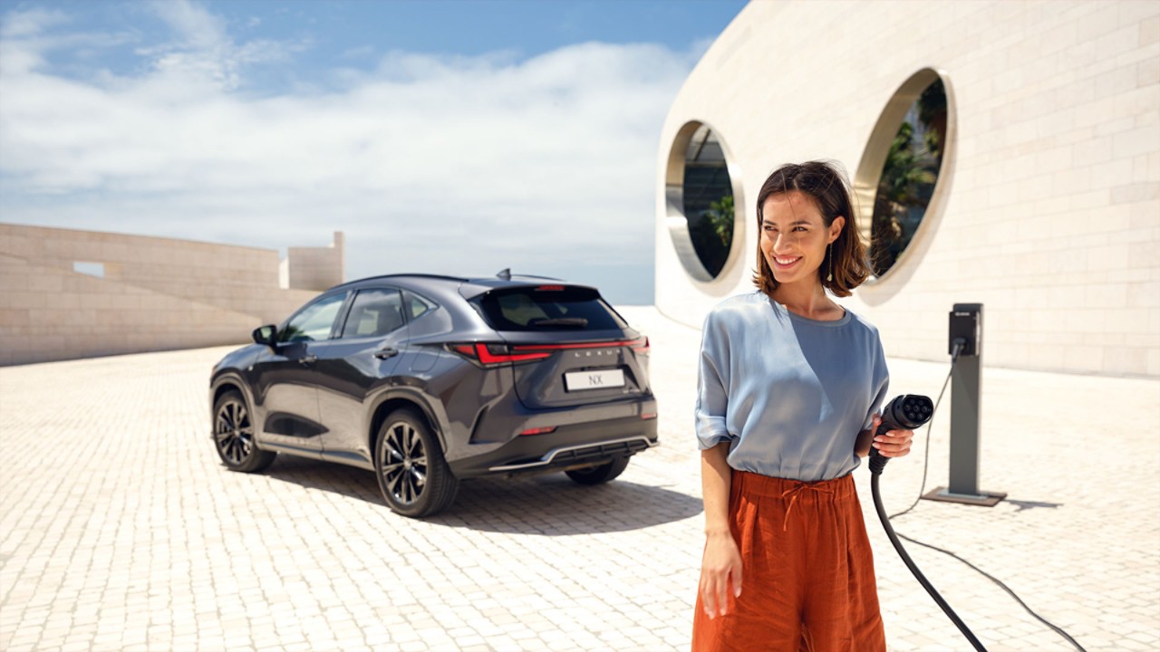 A person plugging in a charging socket into a Lexus NX 